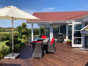 a deck with a table and chairs and an umbrella at Outstanding Close To Nice Beachh in Karrebæksminde