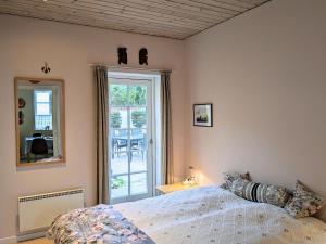 a bedroom with a bed and a mirror and a door at Lovely 2-Story Cabin By The Sea On Bornholm in Svaneke