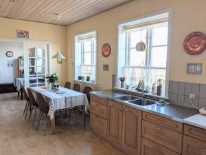 a kitchen with a sink and a table with chairs at Lovely 2-Story Cabin By The Sea On Bornholm in Svaneke
