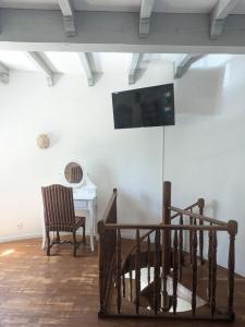 a living room with a tv on the wall and a chair at La Tour in Béziers