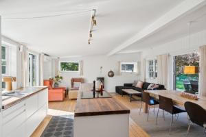a kitchen and living room with white walls at Spacious Summer House With Pool in Vejby