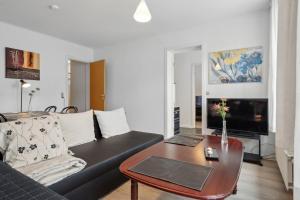 a living room with a black couch and a table at Cozy Apartment In Tønder in Tønder