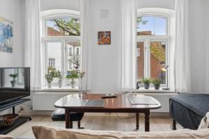 a living room with a coffee table and windows at Cozy Apartment In Tønder in Tønder