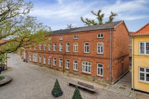 a large brick building with trees in front of it at Cozy Apartment In Tønder in Tønder