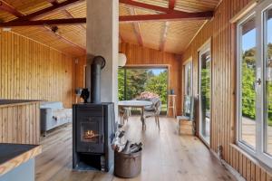 a living room with a wood stove in a house at Romantic Retreat Close To The Beach in Fårevejle