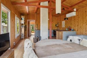 a room with a large bed and a kitchen at Romantic Retreat Close To The Beach in Fårevejle