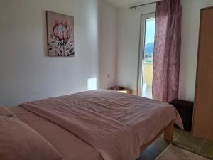 a bedroom with a bed and a window with a view at Apartment Moki in Lastva