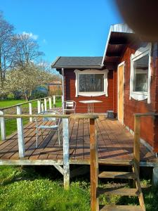 a wooden deck with chairs and a house at Charming Summer House In An Idyllic Area in Gylling +1 photo
