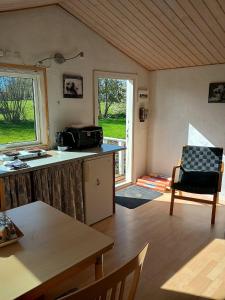 a room with a kitchen with a table and a window at Charming Summer House In An Idyllic Area in Gylling