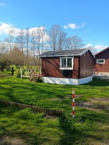 a small house in a yard with a grass field at Charming Summer House In An Idyllic Area in Gylling