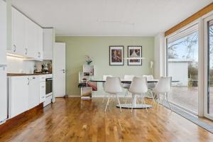 a kitchen and dining room with a table and chairs at Summer House With Fjord View in Kulhuse
