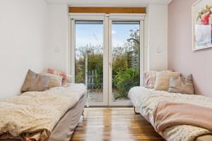 two beds in a room with a window at Summer House With Fjord View in Kulhuse