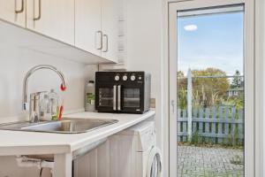 a kitchen with a sink and a microwave at Summer House With Fjord View in Kulhuse