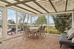 a patio with a table and chairs and a couch at Summer House With Fjord View in Kulhuse
