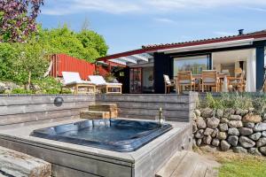 a hot tub in the backyard of a house at Lovely Beach House With Panoramic View in Martofte