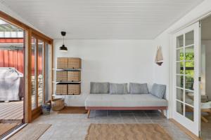 a living room with a couch on a porch at Lovely Beach House With Panoramic View in Martofte