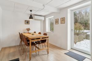 a dining room with a wooden table and chairs at Cosy House Near Forest in Rønne +18 photos