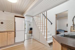 an open kitchen with a stairway leading up to a loft at Cosy House Near Forest in Rønne