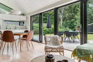 a kitchen and dining room with sliding glass doors at Scenic Summer House In Asserbo in Frederiksværk