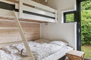 a bedroom in a tiny house with a bunk bed at Scenic Summer House In Asserbo in Frederiksværk