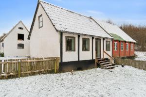 a white and red house in the snow at Cosy House Near Forest in Rønne