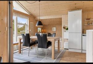 a kitchen and dining room with a table and chairs at Cozy And Well-Maintained Holiday Home in Eskebjerg
