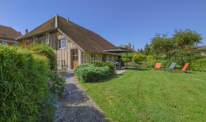 a house with a yard with chairs and a house at Le clos des berdins in Saint-Jean-de-Bonneval