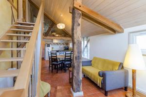 a living room with a yellow couch and a staircase at Le clos des berdins in Saint-Jean-de-Bonneval
