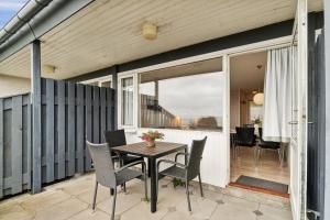 a patio with a table and chairs on a balcony at Lovely Holiday Apartment Consumption Included in Allinge