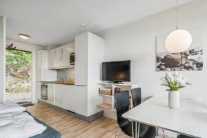 a bedroom with white walls and a white table and a tv at Lovely Holiday Apartment Consumption Included in Allinge +18 photos