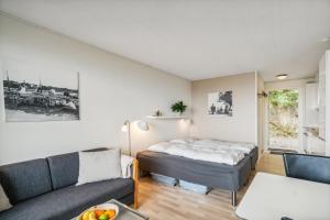 a living room with a bed and a couch at Lovely Holiday Apartment Consumption Included in Allinge