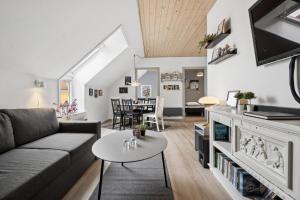 a living room with a couch and a table at Holiday Apartment With Pool On Bornholm in Gudhjem