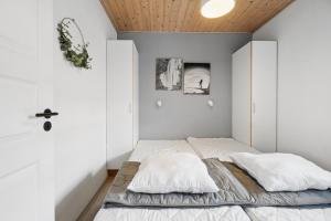 a bedroom with white walls and a bed with two pillows at Holiday Apartment With Pool On Bornholm in Gudhjem