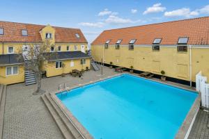 an overhead view of a swimming pool with two buildings at Holiday Apartment With Pool On Bornholm in Gudhjem +12 photos