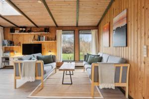 a living room with two couches and a tv at Cozy Summer House In Trend in Løgstør
