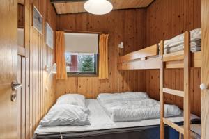 a bedroom with bunk beds and a window at Cozy Summer House In Trend in Løgstør
