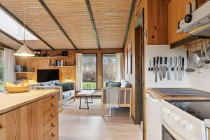 a kitchen and living room with wooden ceilings at Cozy Summer House In Trend in Løgstør +22 photos