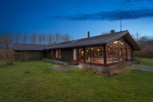 a house with a lot of windows in a yard at Cozy Summer House In Trend in Løgstør