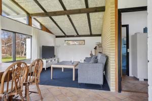 a living room with a couch and a table at Cozy Cottage Near Bjerge Strand in Store Fuglede