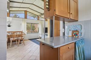 a kitchen with a counter and a dining room at Cozy Cottage Near Bjerge Strand in Store Fuglede +13 photos