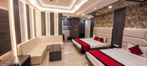 a hotel room with two beds and a couch at Hotel The Novelty in Kānpur