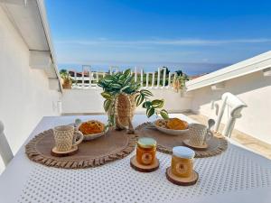 a table with cups and bowls of food on a balcony at Godano Rooms in Drapia +46 photos