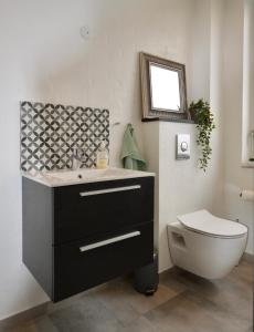 a bathroom with a sink and a toilet at Charming Holiday Apartment In Central Stege in Stege +8 photos