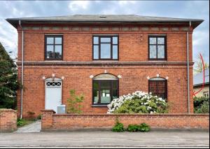 a red brick house with a white door at Charming Holiday Apartment In Central Stege in Stege