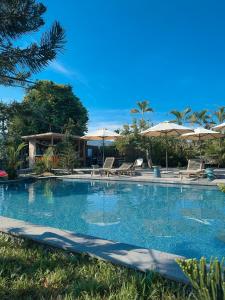 a large swimming pool with chairs and umbrellas at Nam garden lodge in Tân Phú