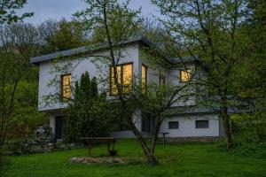 a white house with its lights on in the yard at Sarajevo Hills-POOL&JACUZZI private garden Home-Near Old Town in Sarajevo