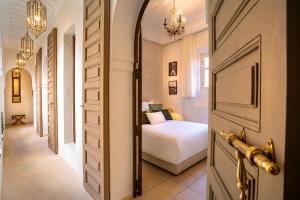 a hallway with a bedroom with a bed and a door at Riad Anaqa in Marrakesh +116 photos