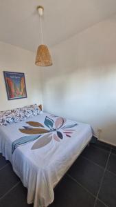 a bedroom with a bed with a flower pattern on it at Grand T3 face au port avec sa terrasse , parking privatif in Saint-Cyprien-Plage