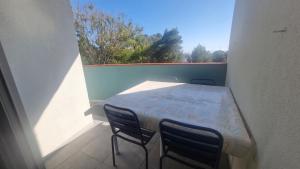 a balcony with a table and chairs and a window at Grand T3 face au port avec sa terrasse , parking privatif in Saint-Cyprien-Plage +5 photos