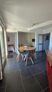 a kitchen and dining room with a table and chairs at Grand T3 face au port avec sa terrasse , parking privatif in Saint-Cyprien-Plage
